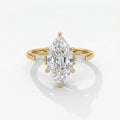 Marquise diamond engagement ring with tapered baguette side stones in polished yellow gold on white background