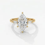 Marquise diamond engagement ring with tapered baguette side stones in polished yellow gold on white background