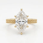 Yellow gold marquise cut diamond engagement ring with detailed milgrain engraving and elegant solitaire design.