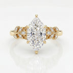 Marquise diamond engagement ring in yellow gold with leaf-inspired diamond accents on a clean white background