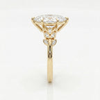 Side profile of marquise diamond engagement ring featuring elevated yellow gold setting and leaf accents