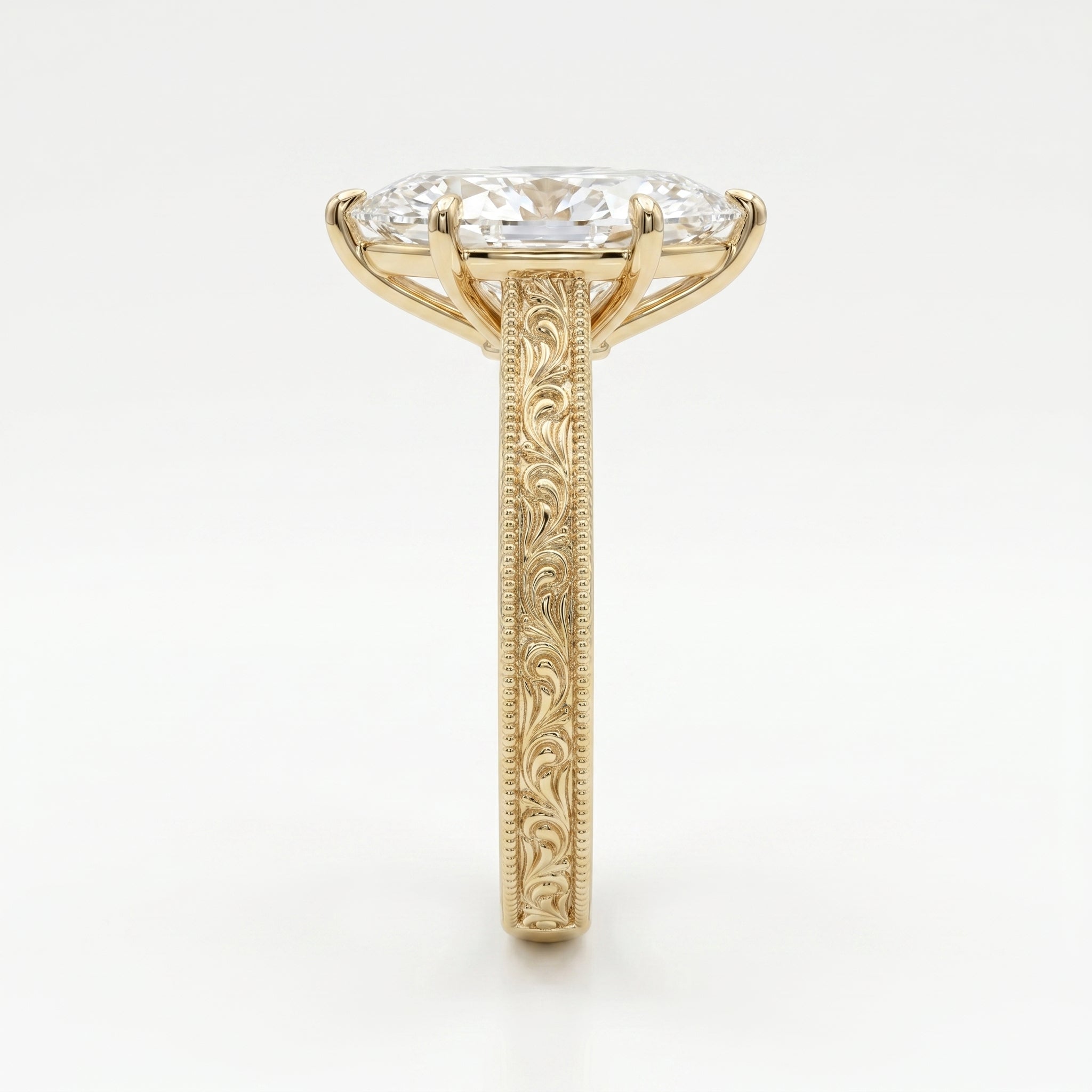 Side profile of marquise diamond engagement ring showing elevated setting and detailed gold engraving