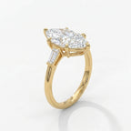 Luxury marquise cut diamond ring in yellow gold showing baguette accents from elegant 45 degree angle