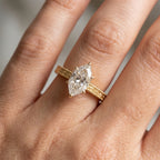 Marquise diamond engagement ring worn on hand highlighting elegant proportions and vintage gold details