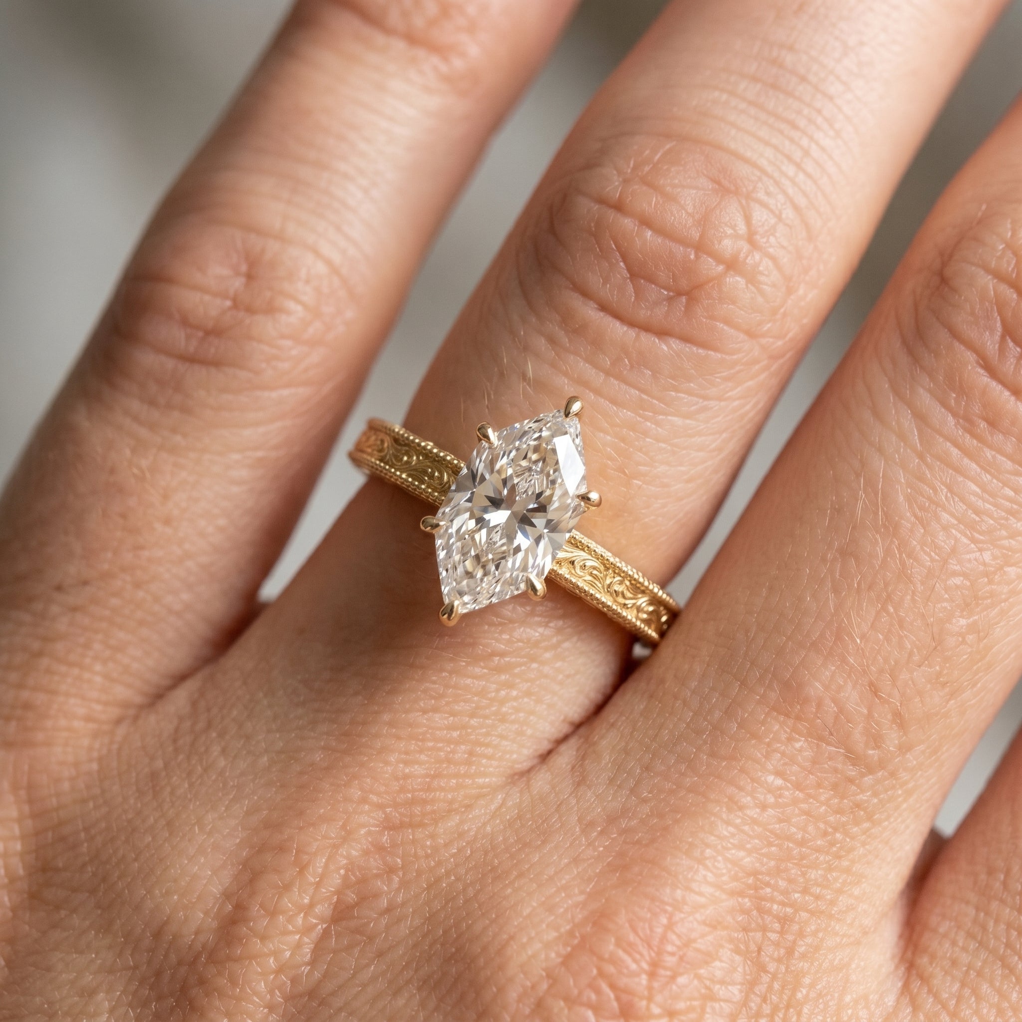Marquise diamond engagement ring worn on hand highlighting elegant proportions and vintage gold details
