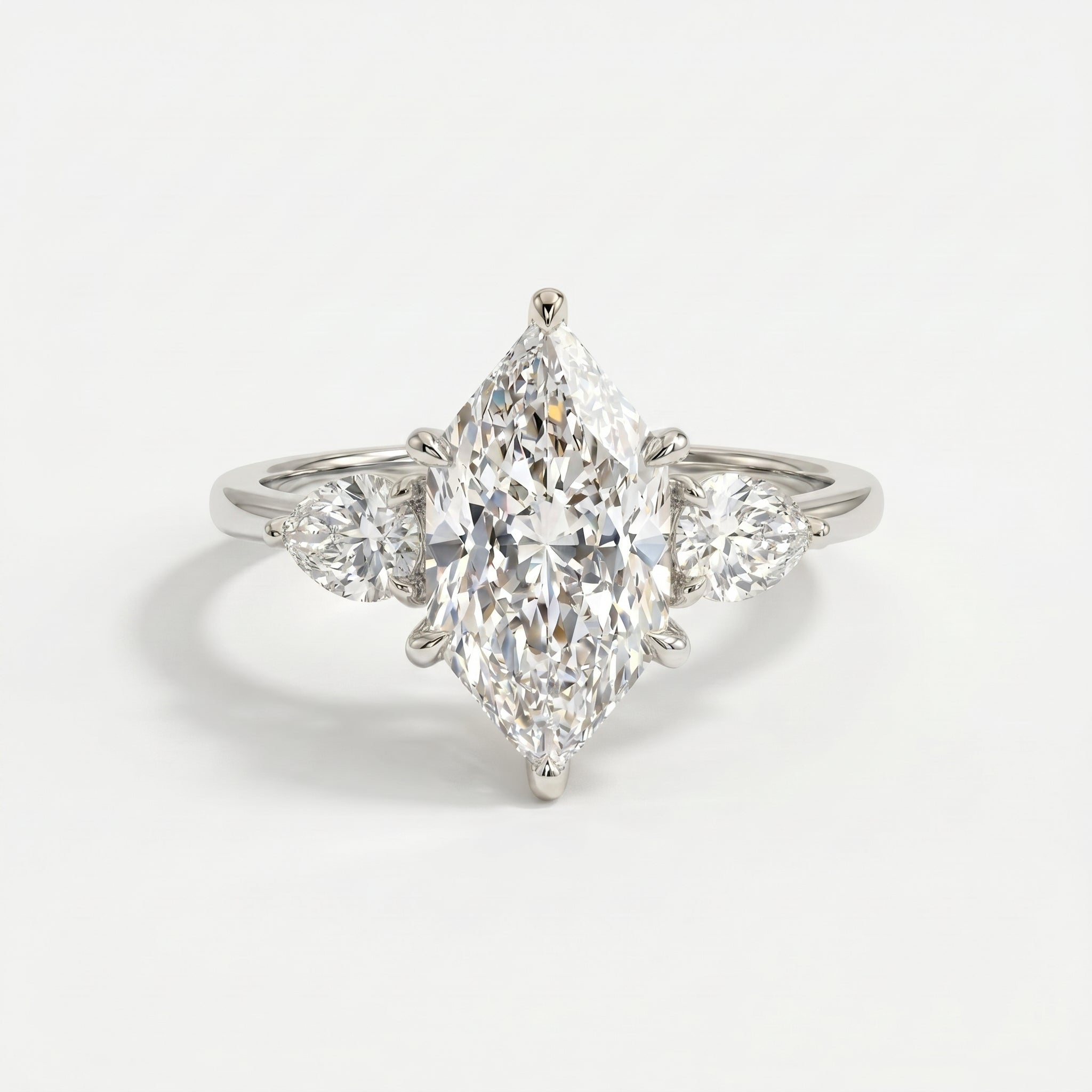 Top view of marquise center diamond ring with matching pear side stones in elegant three stone design