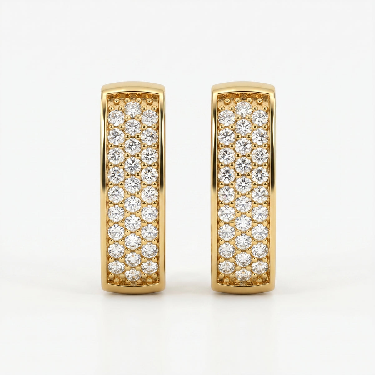 Yellow gold and silver pavé huggie earrings comparison with sparkling stones on white background