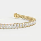 Yellow gold pear diamond tennis bracelet photographed at 45-degree angle highlighting brilliance and craftsmanship