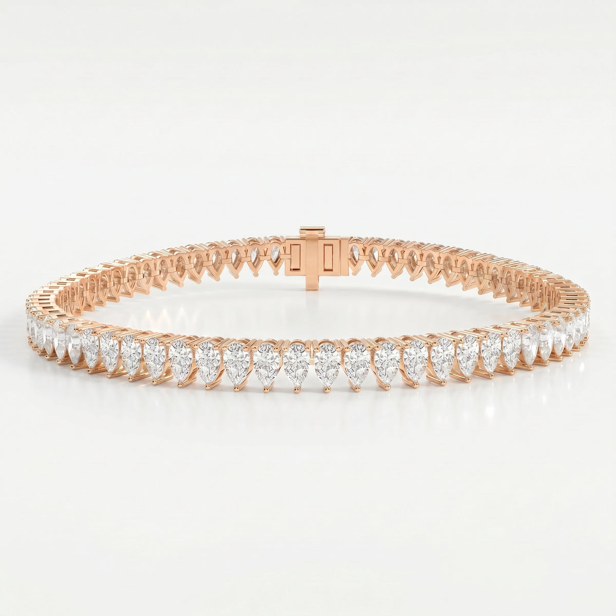 Top view flat lay of pear cut diamond tennis bracelet in yellow gold on clean white background