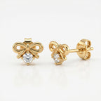 Woman wearing minimalist rose gold bow earrings with sparkling crystal in elegant everyday styling