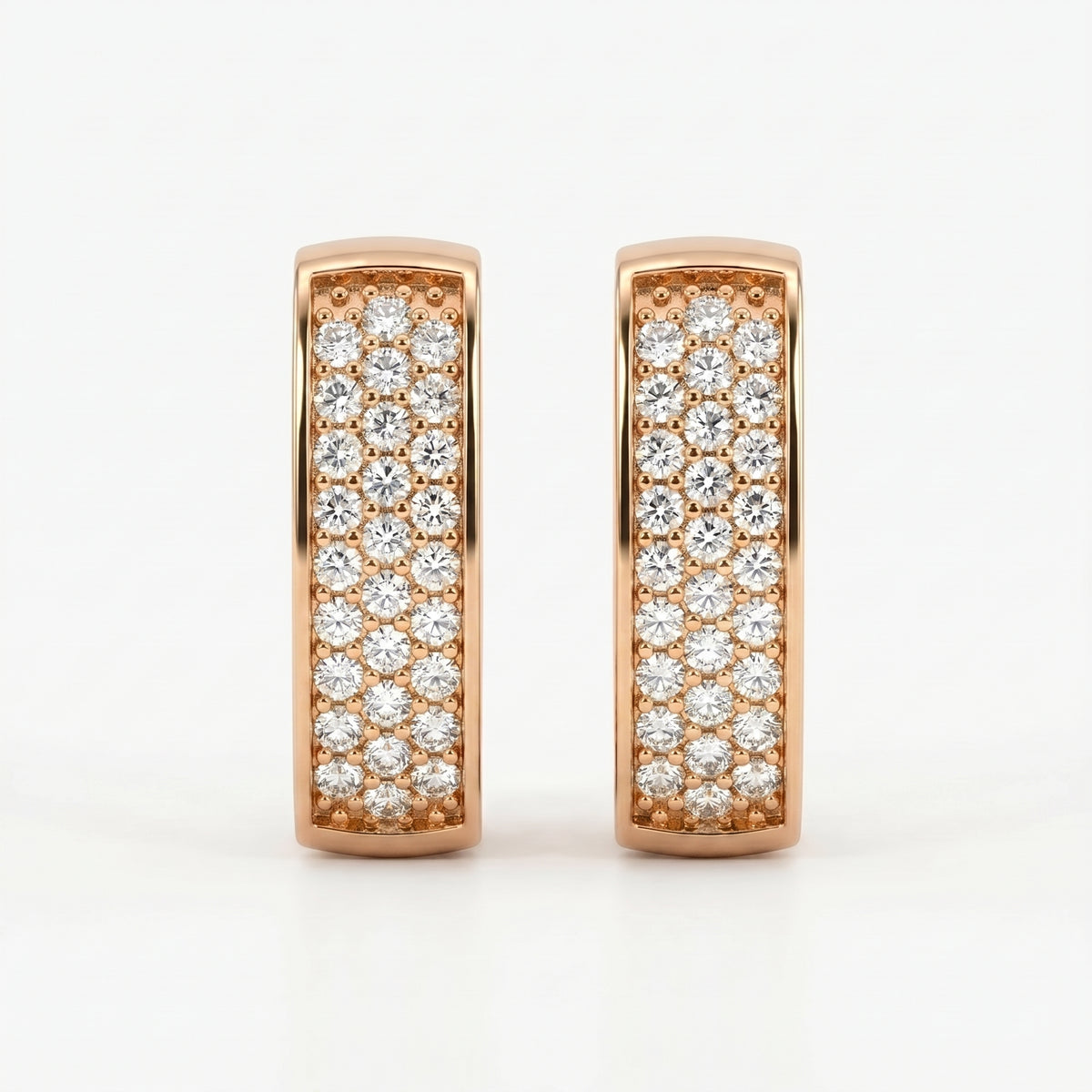 Rose gold pavé huggie earrings with sparkling round diamonds on a clean white luxury jewelry background