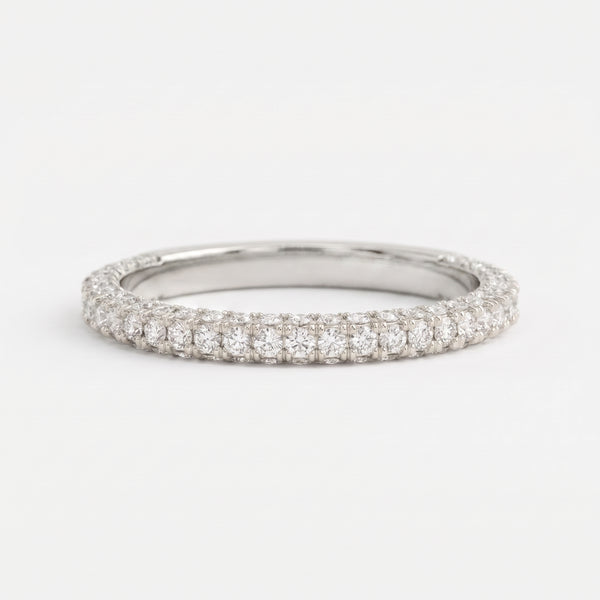 Round brilliant diamond eternity wedding band in polished white gold with shared prong setting on a clean white background.