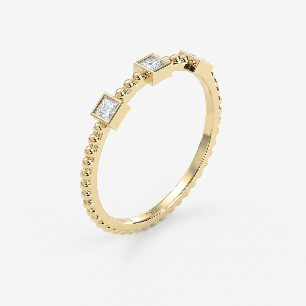 Angled view of beaded yellow gold ring featuring three princess-cut diamonds in sleek geometric bezel settings