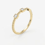 Angled view of beaded yellow gold ring featuring three princess-cut diamonds in sleek geometric bezel settings