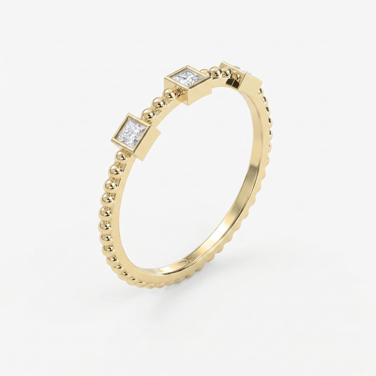 Angled view of beaded yellow gold ring featuring three princess-cut diamonds in sleek geometric bezel settings