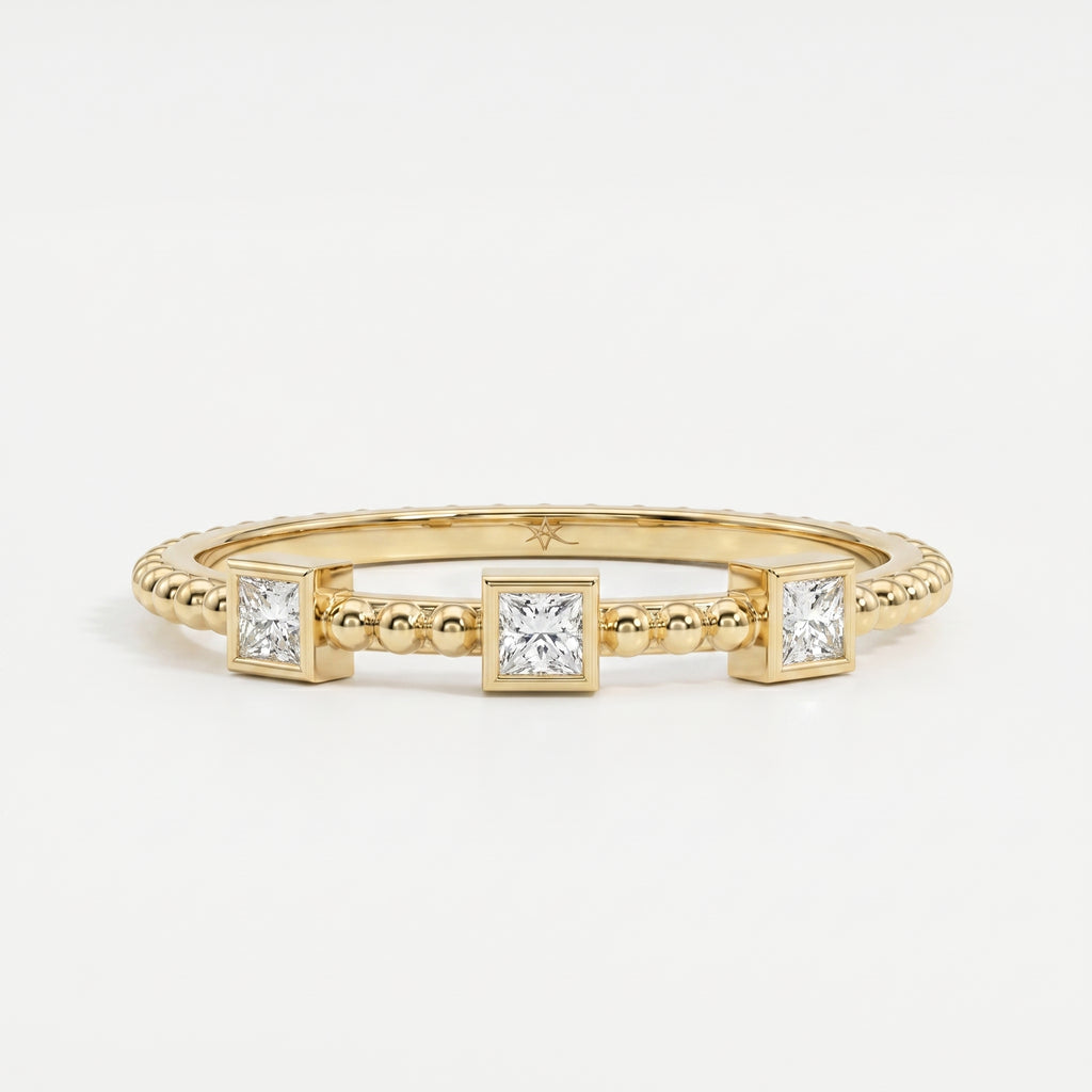 Three princess-cut diamond beaded yellow gold ring with modern bezel settings and minimalist luxury design