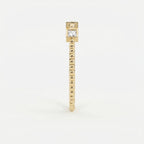 Side profile of yellow gold diamond stacking ring showing low bezel settings and beaded band detail