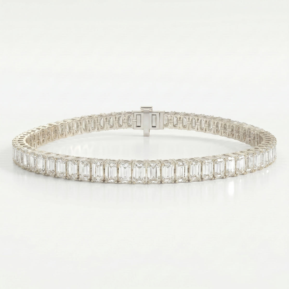 White gold emerald cut diamond tennis bracelet featuring a full eternity design with secure clasp and brilliant diamonds.