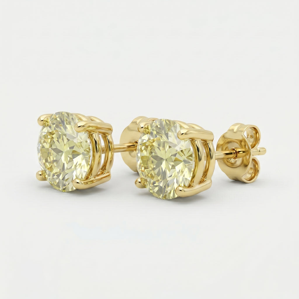 Luxury yellow diamond stud earrings in polished yellow gold with round-cut stones and four-prong basket setting
