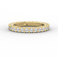 Yellow gold full eternity diamond ring with round brilliant diamonds in a shared prong setting on a pure white background.