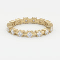 Yellow gold diamond eternity band with round brilliant diamonds in a modern shared-prong setting on white background