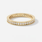 Yellow gold diamond eternity band ring with round brilliant diamonds in a polished luxury wedding band design