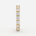 Side profile of a yellow gold diamond eternity ring highlighting the shared U-prong setting and polished comfort-fit band.