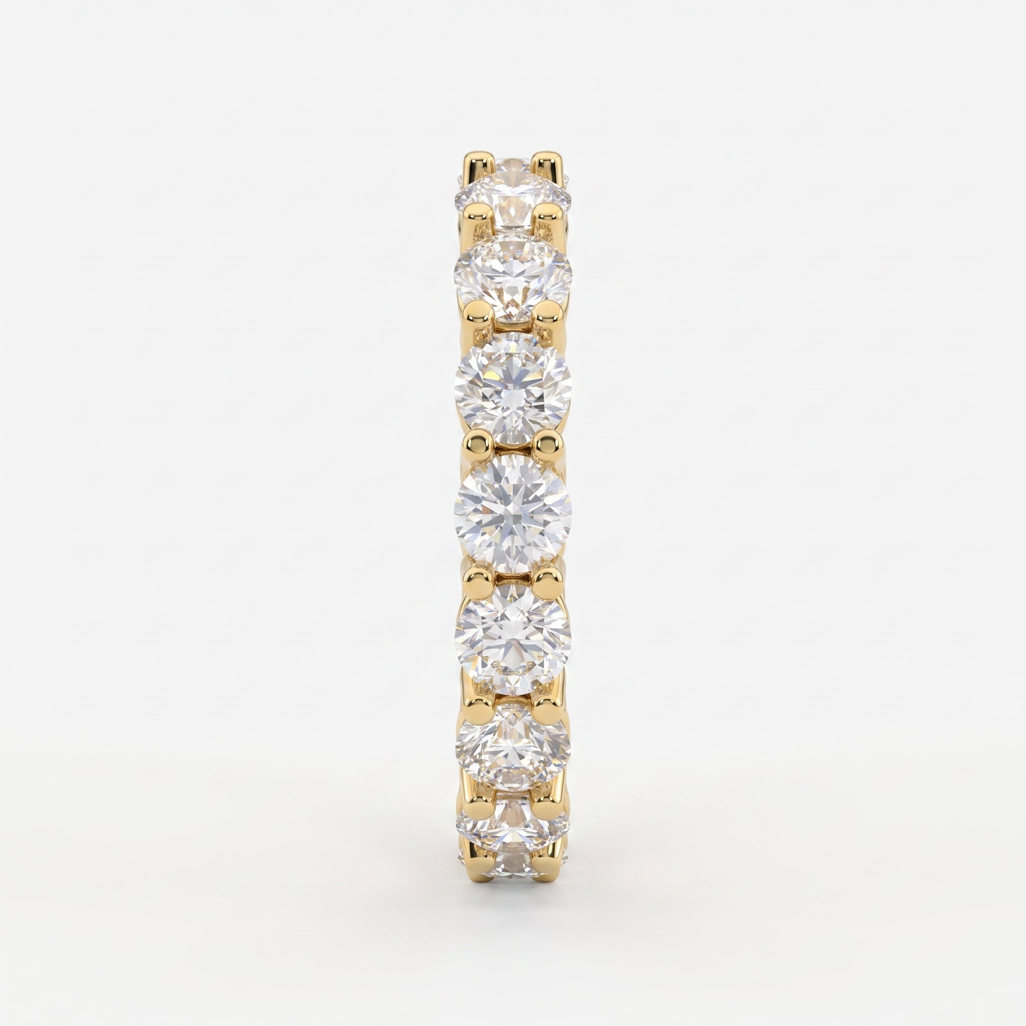 Side profile of a yellow gold diamond eternity ring highlighting the shared U-prong setting and polished comfort-fit band.