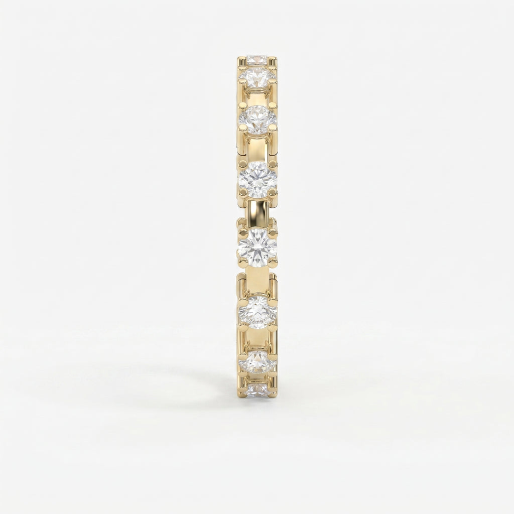 Side profile of yellow gold diamond eternity ring showing open gallery and shared-prong craftsmanship