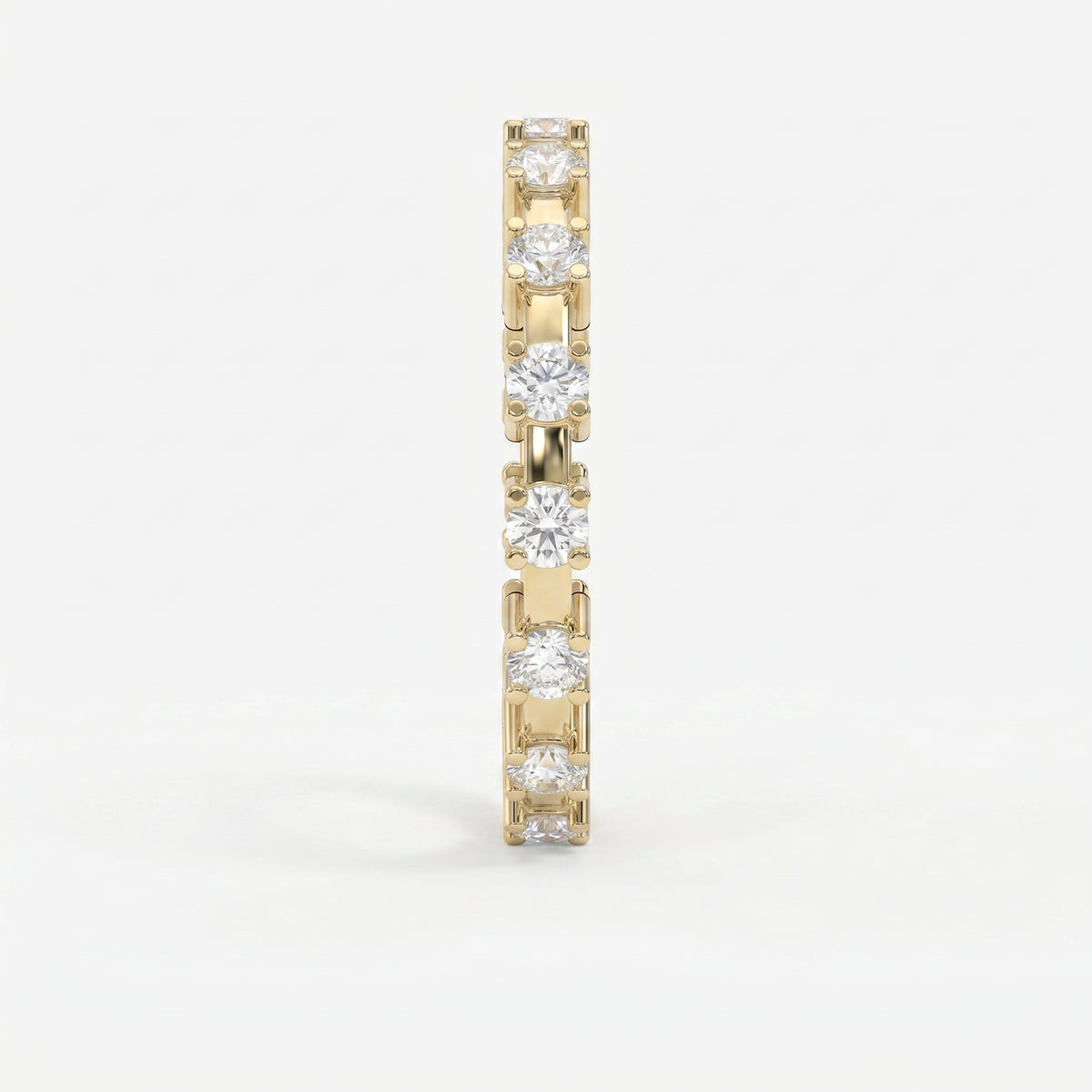 Side profile of yellow gold diamond eternity ring showing open gallery and shared-prong craftsmanship