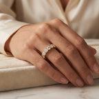 Yellow gold diamond eternity ring with round brilliant diamonds worn on hand, showcasing elegant shared prong design and luxury sparkle.