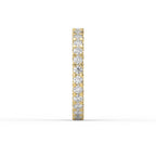  Side profile of a yellow gold eternity band showcasing shared prong diamond setting and polished gold finish.